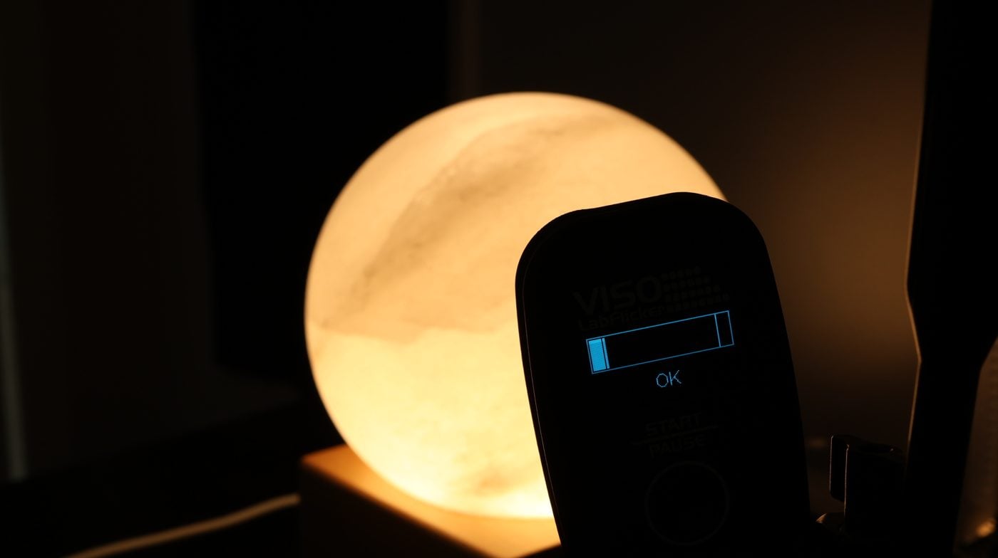 A flicker meter measuring a glowing salt-sphere sunrise clock in a dark room