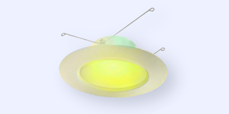 A recessed ceiling light fixture with a round trim, emitting a soft yellow glow, and two metal spring arms for mounting.