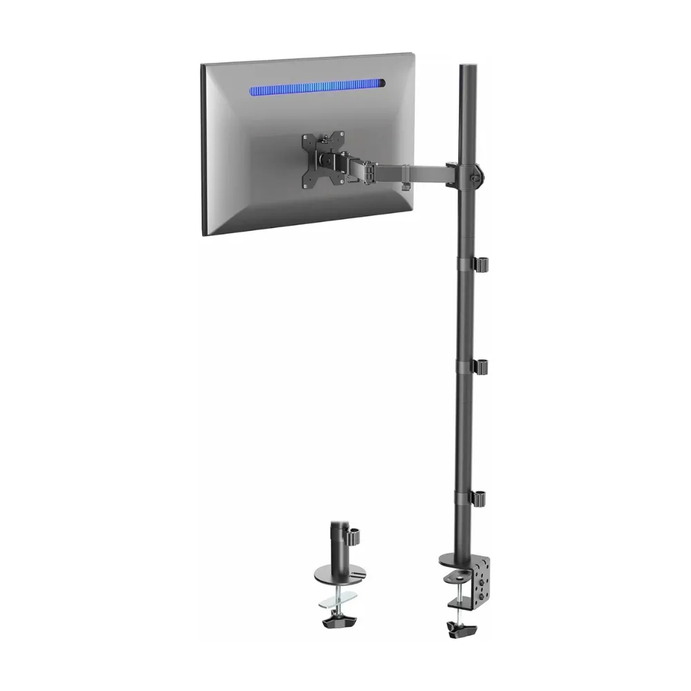 A monitor arm stand is clamped to the edge of a desk, holding a flat-screen monitor. The stand is tall, with adjustable arms and cable management clips along the pole.