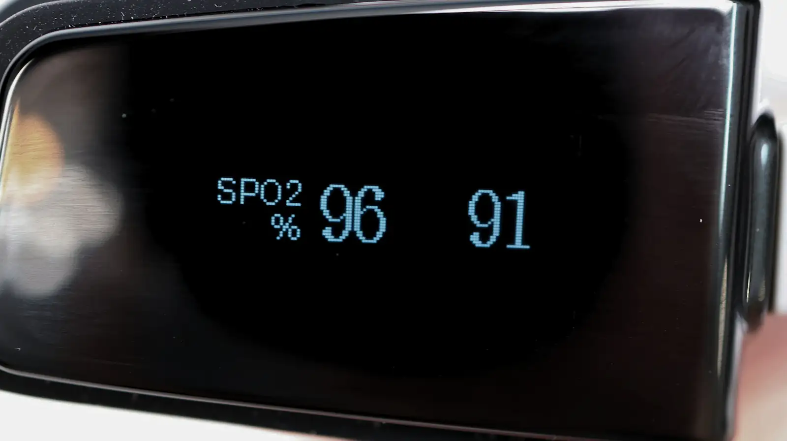 A digital display showing SPO2 at 96 percent and a pulse rate of 91, likely from a medical device such as a pulse oximeter.
