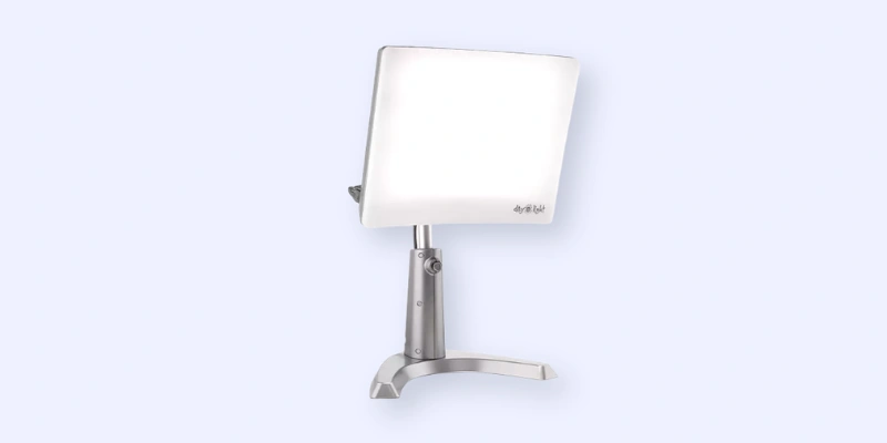 A rectangular white LED therapy light mounted on an adjustable silver metal stand, set against a light blue background.