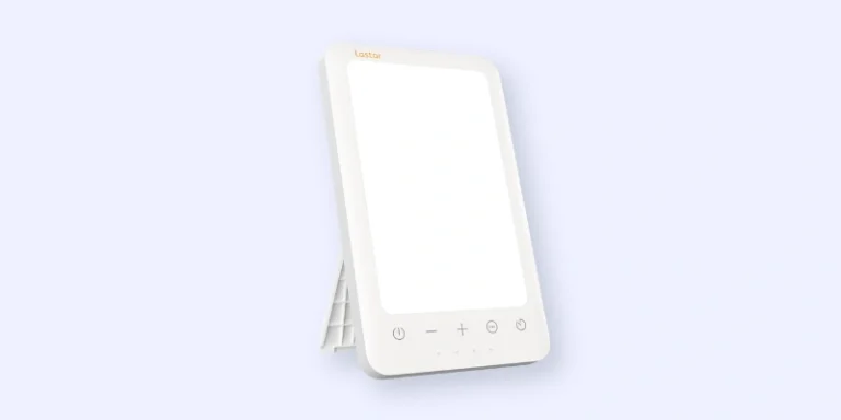 A rectangular white therapy light with touch controls and a stand, positioned at an angle against a light blue background.