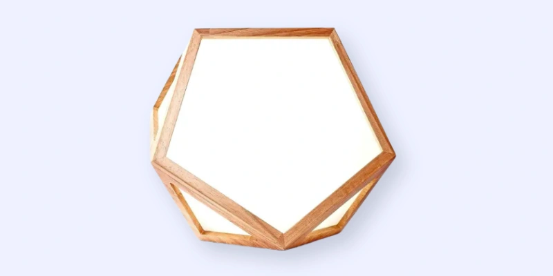 A geometric ceiling light fixture with a wooden hexagonal frame and frosted white panels, photographed against a plain light background.