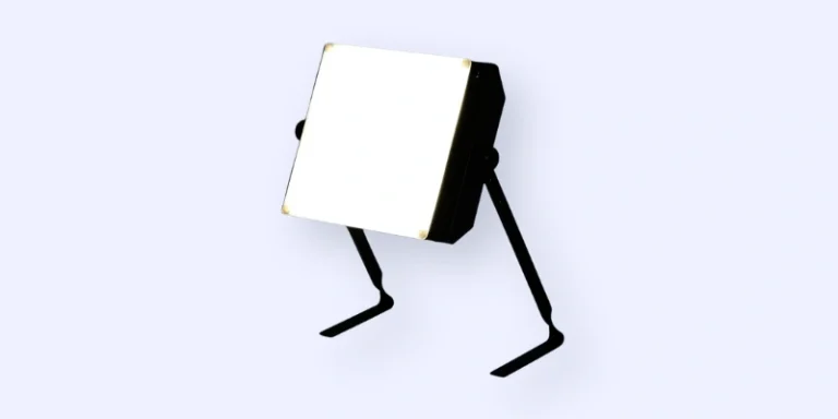 A square-shaped LED light panel with a bright white surface is mounted on two angled black legs, standing on a light background.