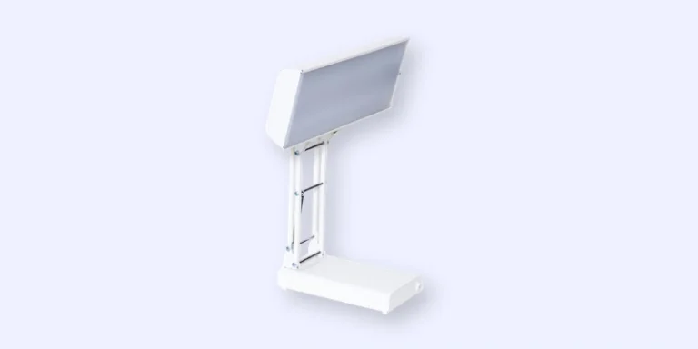 A white, modern desk lamp with a rectangular, angled light head and a sturdy base, set against a light grey background. The lamp has a minimalist, contemporary design.