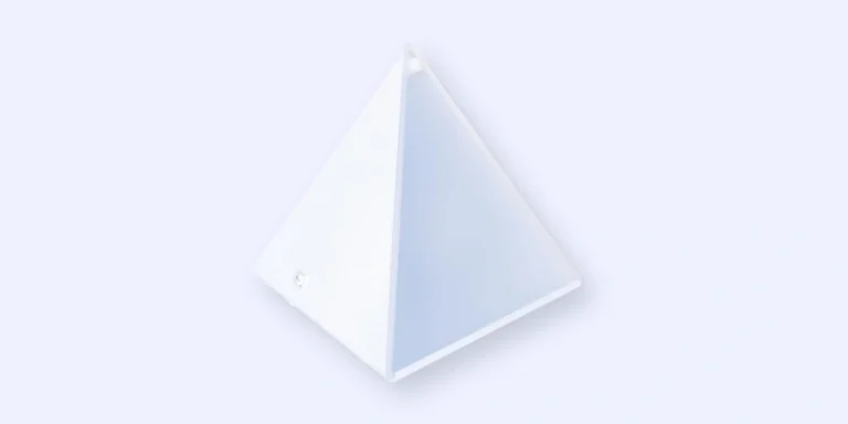 A white, four-sided pyramid with smooth surfaces is shown against a light gray background, viewed from above at an angle.