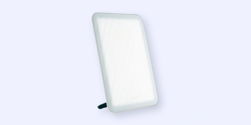 A rectangular LED light therapy lamp with rounded edges, standing upright on a built-in stand against a plain light background.