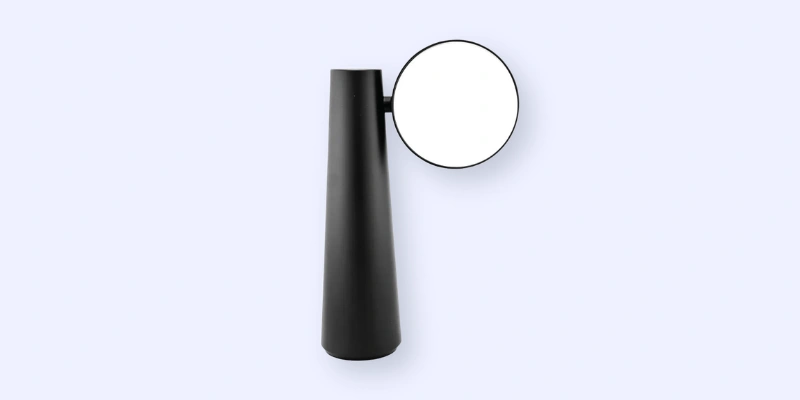 A sleek, modern black vase with a round mirror attached near the top, set against a plain light background.