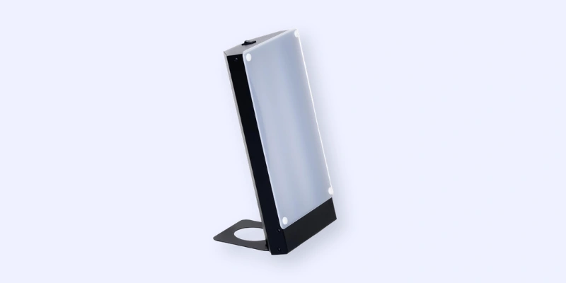 A rectangular electronic device with a frosted front panel and a black, angled stand, shown against a plain light background.