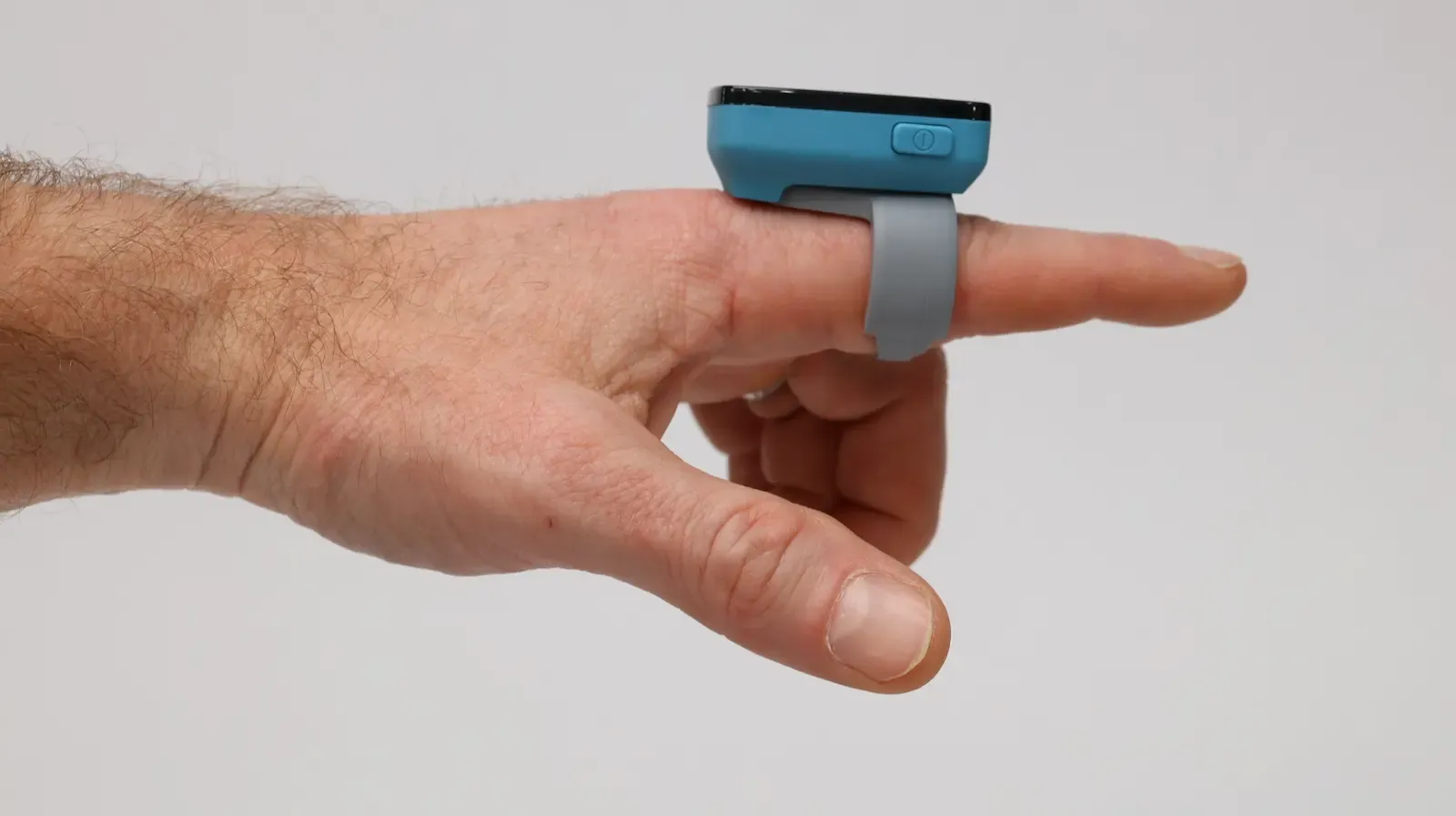 Blue pulse oximeter finger sensor on index finger measuring blood oxygen saturation SpO2 levels