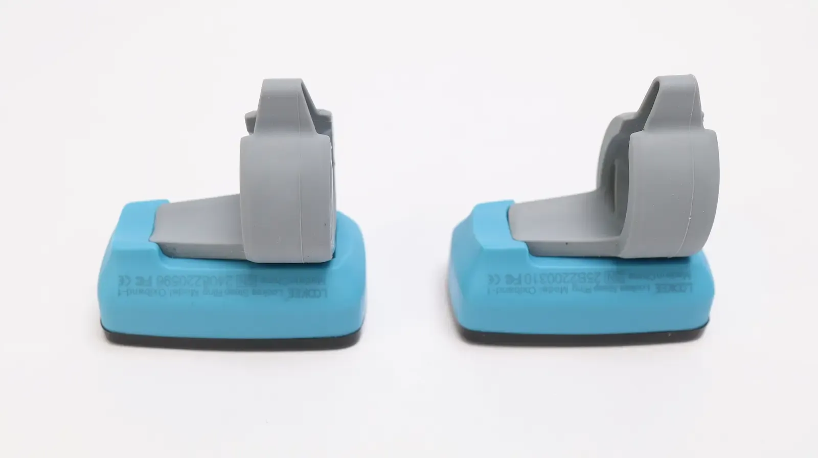 Two Lomiee Sleep Ring Oxiband-1 pulse oximeter finger clip sensors on blue charging docks