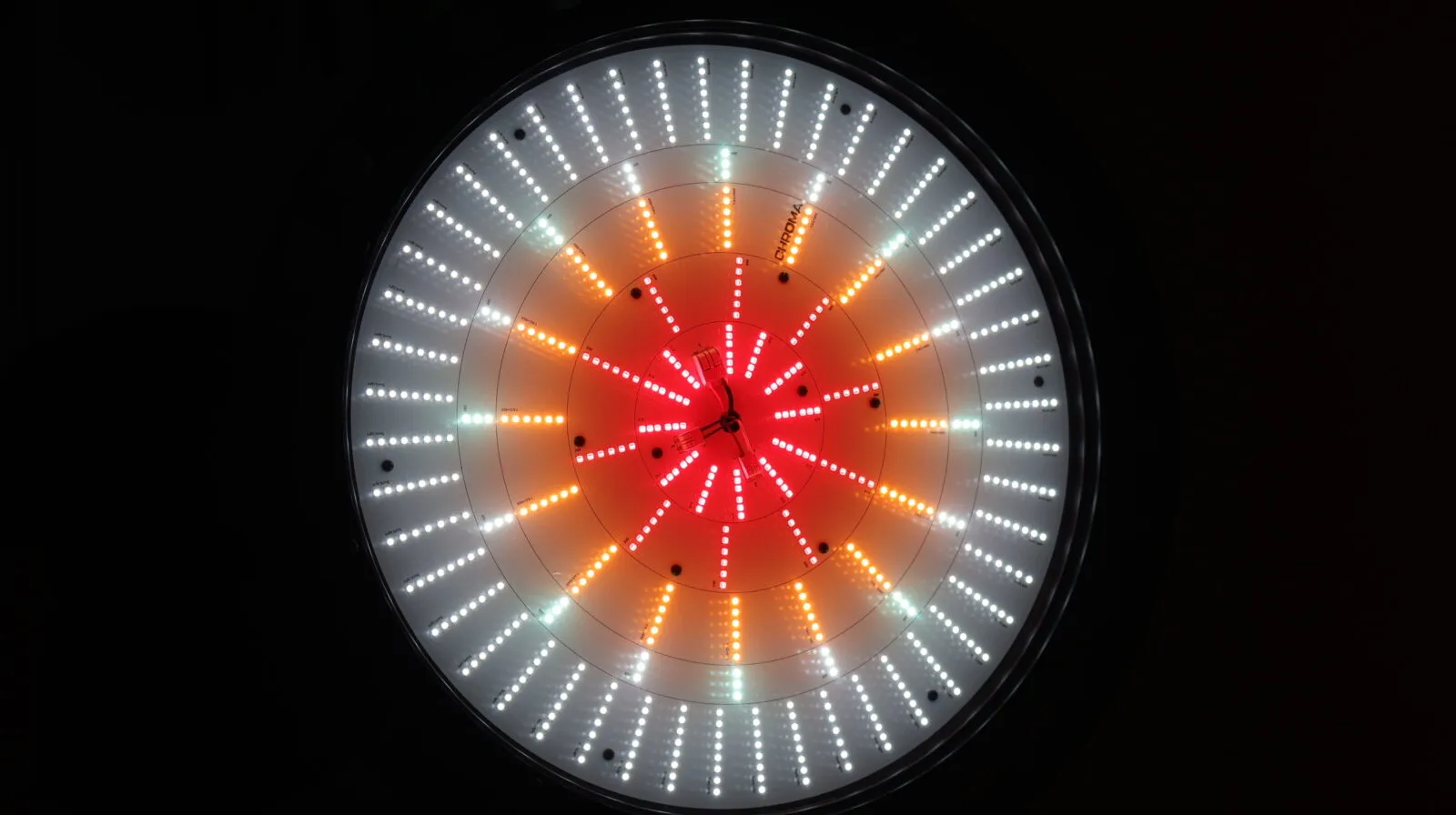 Circular LED grow light panel with red, orange, and white LEDs arranged in concentric rings against black background