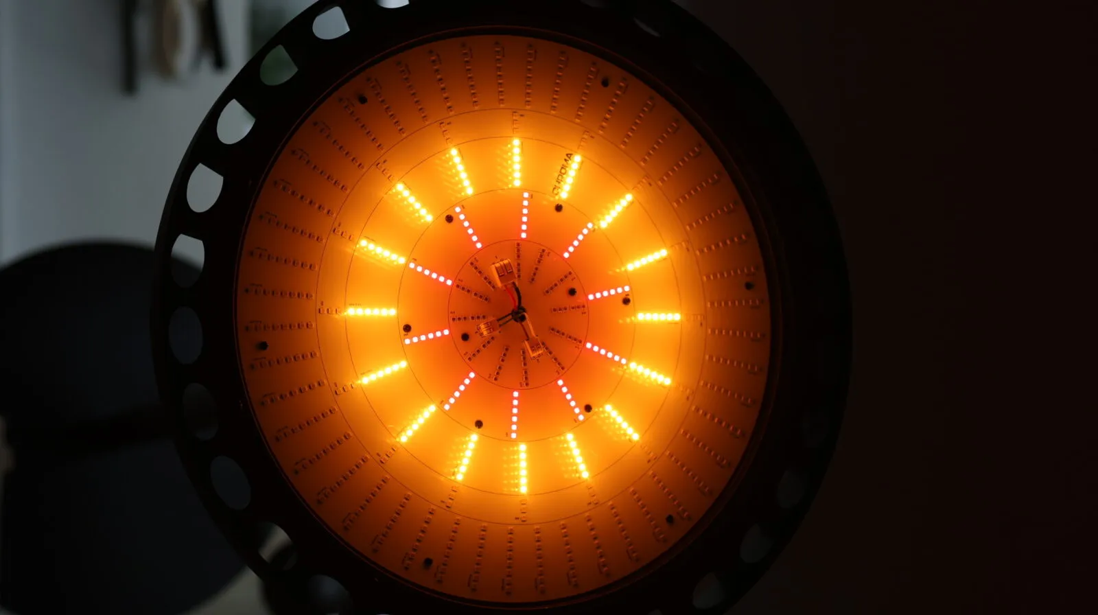 Circular LED grow light panel with red, orange, and white LEDs arranged in concentric rings against black background