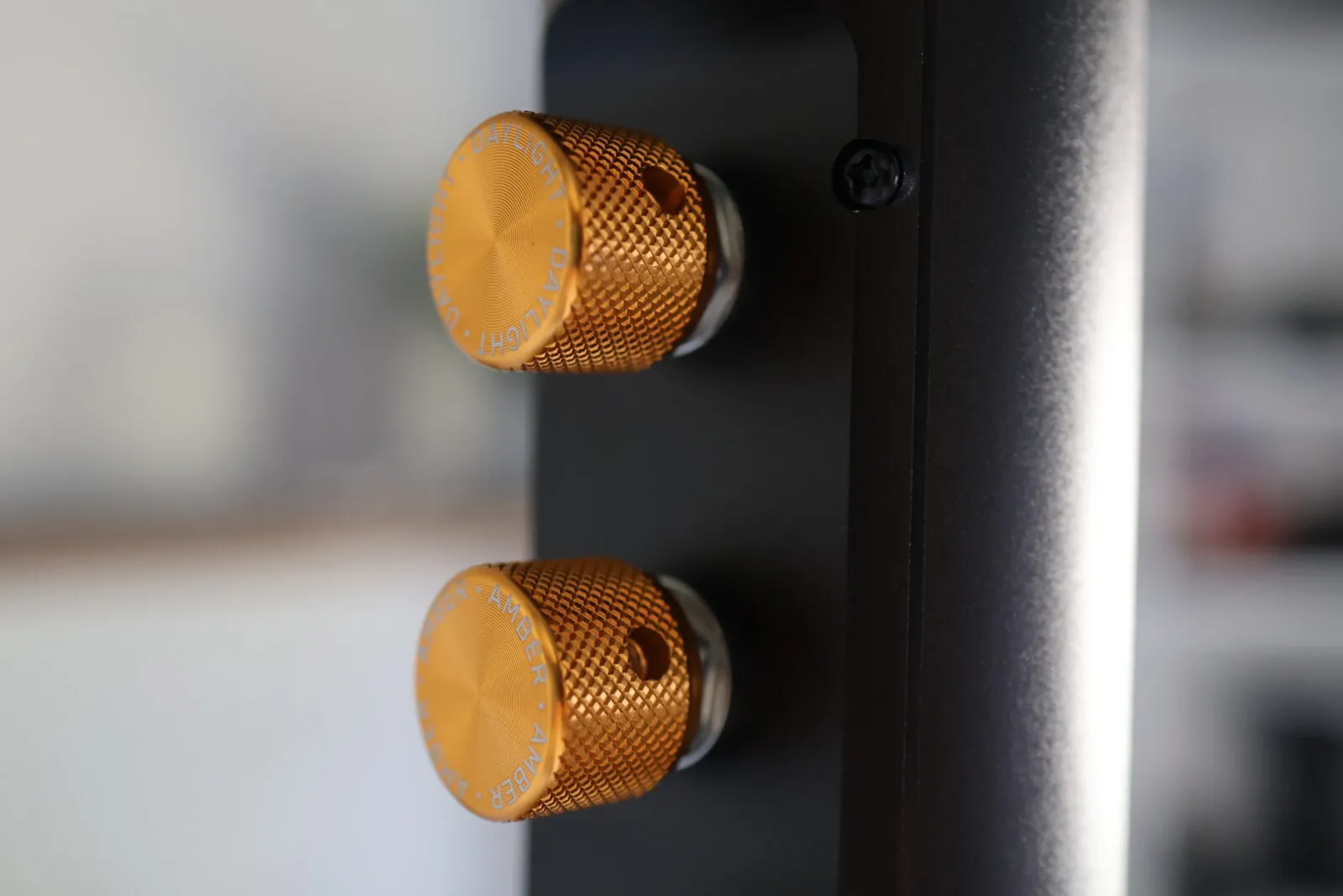Two gold anodized aluminum knurled control knobs labeled Daylight and Amber on a black LED video light panel