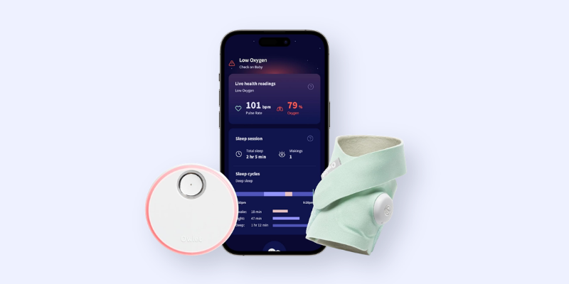 Baby health monitor sensor with mint wrap accessory and smartphone app showing 101 BPM pulse rate and 79% oxygen alert