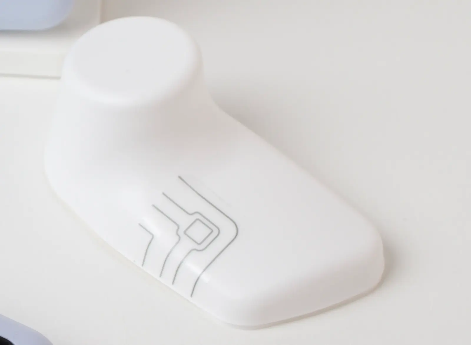 White smart home door/window sensor with circuit board icon on desk, compact IoT security device
