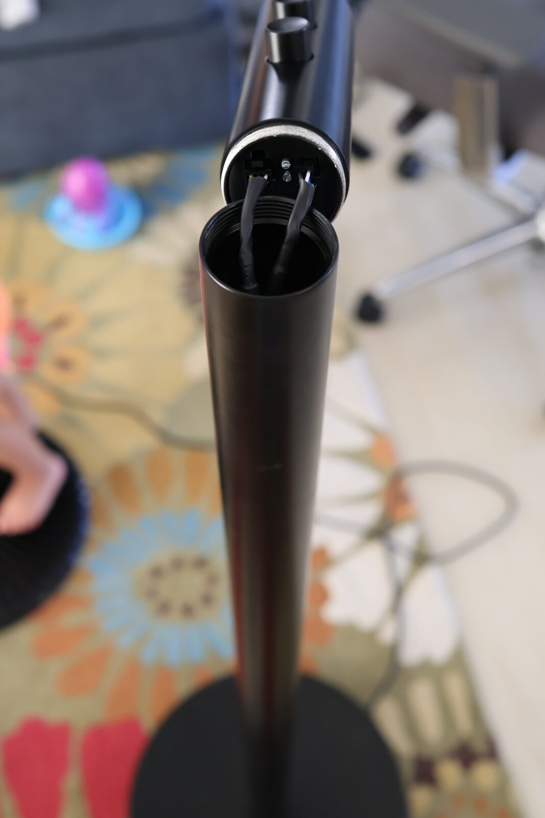 Floor lamp pole top showing open socket with exposed electrical wires during assembly or repair
