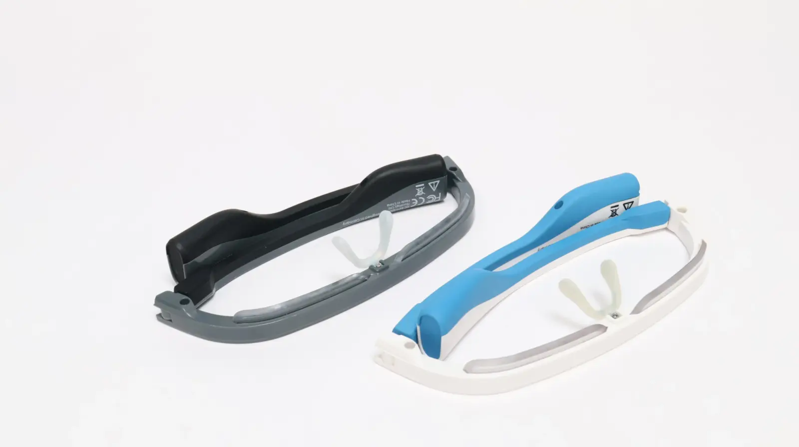 Two smart AR glasses frames side by side — dark gray and white with blue accents — lensless, shown upside down