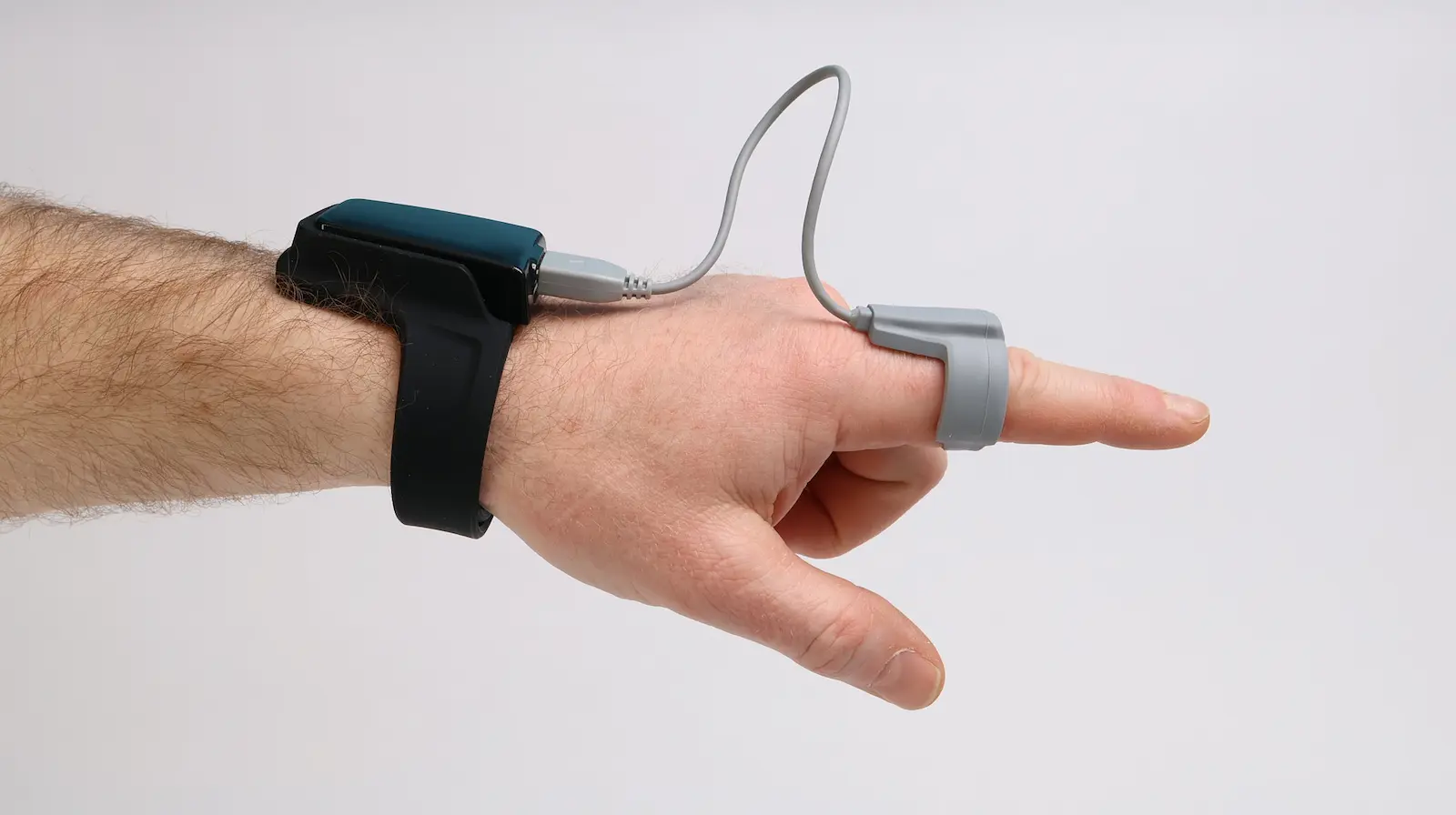 Wrist-worn sleep tracker with pulse oximeter finger sensor connected by cable for overnight health monitoring
